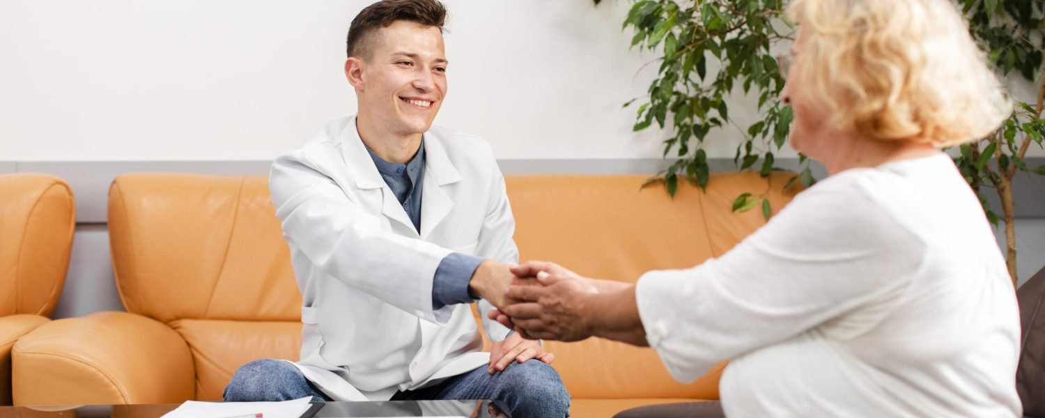 doctor-sitting-sofa-holding-patient-hand